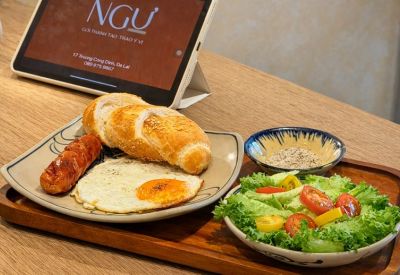 Breakfast platter with eggs, sausage, and bread served next to a digital tablet.