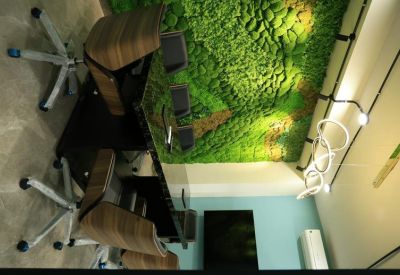 Professional meeting room featuring a moss wall, high-end wooden desk, and circular pendant lighting.