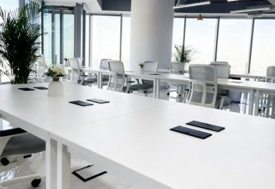 Open-plan workspace with multiple desks and panoramic windows.