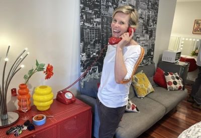 Bright workspace featuring a gray sofa, colorful cushions, and a red vintage rotary phone.