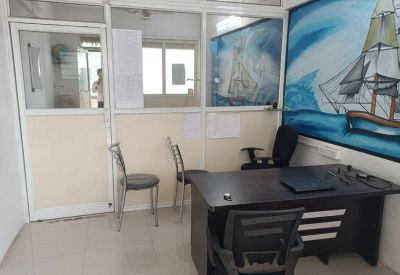 Workspace featuring a dark wood desk and a large wall mural of a sailing ship.