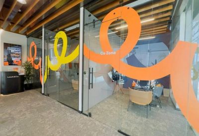 Glass-walled office corridor featuring vibrant orange and yellow decorative vinyls.