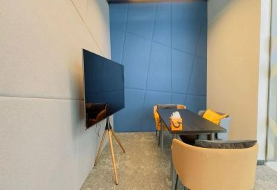 Meeting room with a large TV monitor and a blue geometric feature wall.