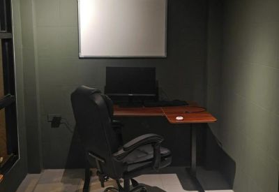 Private workstation with an ergonomic chair, L-shaped desk, and a whiteboard.