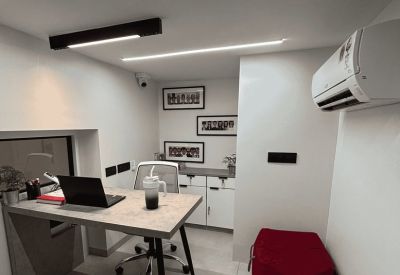 Private office with a grey desk, black laptop, and a red beanbag chair.