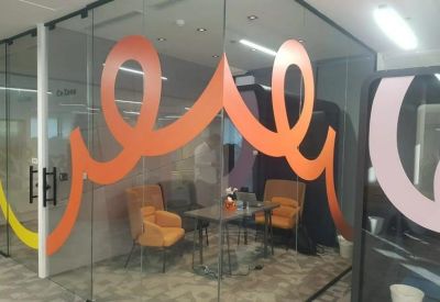 Meeting room with orange wall graphics and armchairs at 3614, الامير مقرن بن عبدالعزيز.