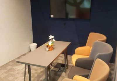Private meeting area with a navy accent wall and multi-colored armchairs.