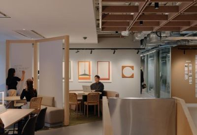 Bright coworking area featuring a whiteboard partition and wooden furniture.