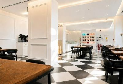 Spacious cafe and lounge area at 3C, Expo Village Boulevard, Building 3D with checkered floors and wooden tables.