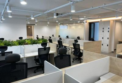 Bright office layout with multiple workstations and a large white storage cabinet.