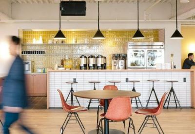 Cafe-style communal area with a tiled service bar, barstools, and modern pendant lighting.