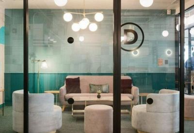 Lounge area with plush velvet seating and a frosted glass partition featuring a circular logo.