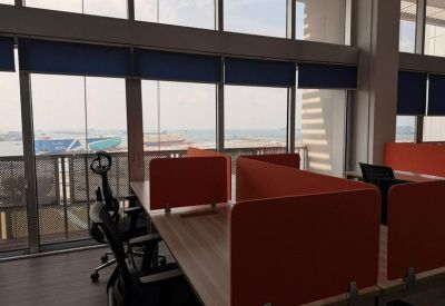 Bright open-plan workspace with orange privacy screens and expansive window views.