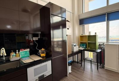 Sleek office kitchenette with dark cabinetry, integrated microwave, and tall windows.