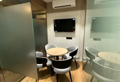 Breakout area with high tables, mismatched chairs, and a dark accent wall.