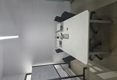 Minimalist meeting room with a white table and natural lighting.