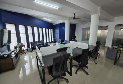 Spacious open-plan workspace with multiple desks and blue accent wall.
