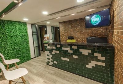 Modern reception desk with a green pixelated pattern and a moss feature wall.