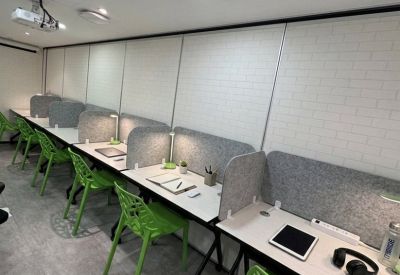 Study cubicles with green chairs and privacy dividers.