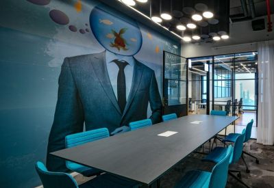 Meeting room with a creative man-in-suit mural and blue chairs.