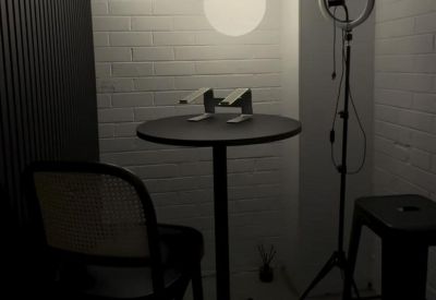 Quiet breakout nook featuring a high table with laptop stands and minimalist globe pendant lighting.