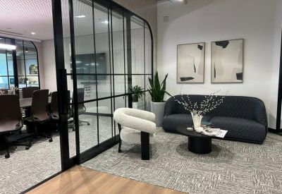 Stylish lounge area featuring a grey sofa, white accent chair, and large abstract wall art.