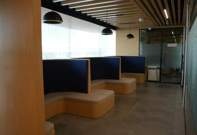 Hallway seating area with semi-private booths under wooden ceiling slats.