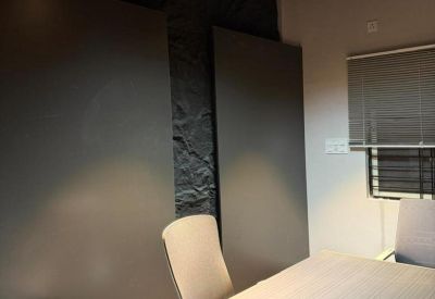 Private office suite with a dark feature wall, wooden ceiling, and track lighting.