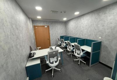 Multi-person office suite with white desks and teal privacy screens.