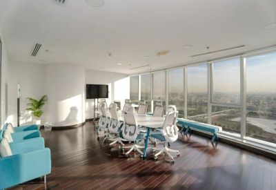 Spacious meeting room featuring a white boardroom table and panoramic city views.