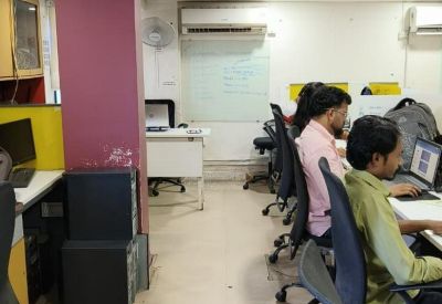 Coworking space with natural light and a central walkway between desk rows.