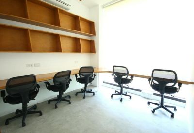 Private office space with a built-in wooden desk and matching wall shelving.