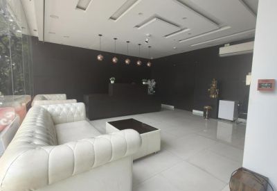 Bright lobby with plush white button-tufted sofas and dark accent walls.