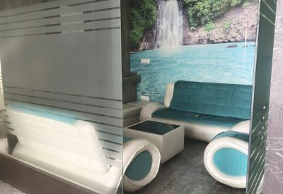 Lounge area behind a glass partition with a nature-themed mural and modern furniture.
