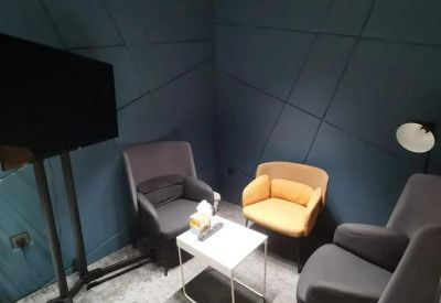 Cozy breakout area with a dark blue geometric accent wall and comfortable lounge seating.