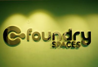 Office lobby with Foundry Spaces sign and potted plants.