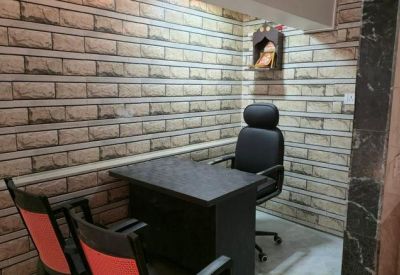 Private office with a dark desk, executive chair, and textured stone-patterned walls.