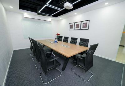 A professional meeting room at Hà Đô Airport Building with a large wood-finish table and black mesh chairs.