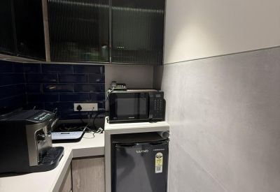 Breakroom kitchenette with dark cabinets, a microwave, and a small refrigerator.