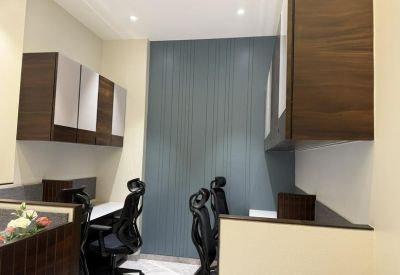 Private desk area featuring dark wood overhead cabinetry and a grey feature wall.