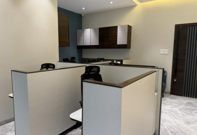 Modern cubicle workstations with white partitions and black ergonomic chairs.