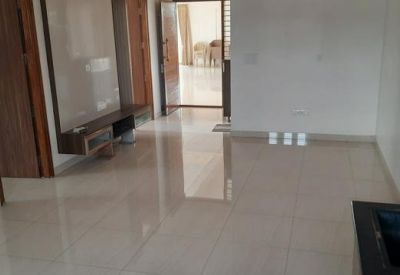 Empty hallway and entrance area with reflective tiling and dark wood cabinetry.