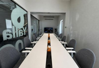 Spacious boardroom at Obhur with a long white conference table and multiple grey ergonomic chairs.