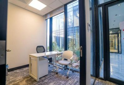 Small office with a single desk and garden view.