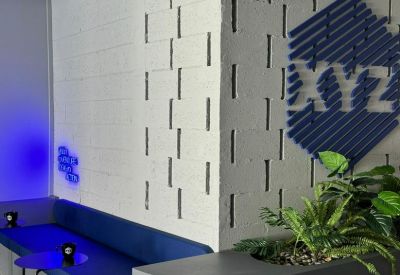 Lounge area corner with built-in planter box and a large 'XYZ' logo on the wall.