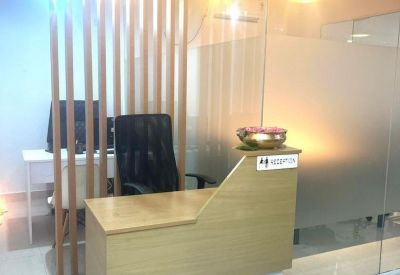 Reception desk featuring light wood finishes and warm hanging pendant lights.