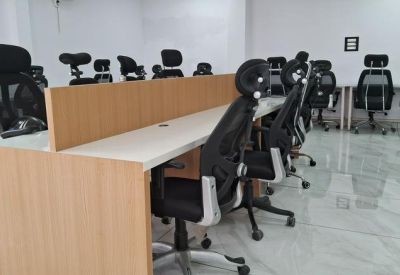Detailed view of shared office workstations with wooden dividers and tiled flooring.