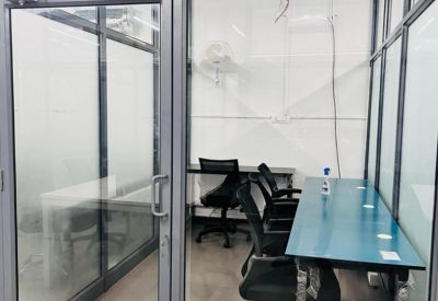 Internal office suite with glass walls and multiple desks.