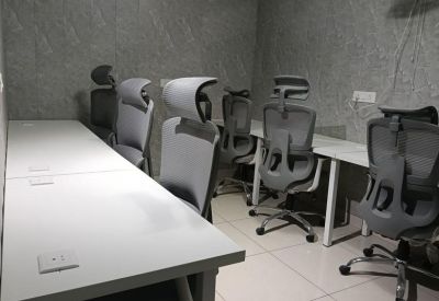 Private office space with several modern ergonomic chairs and white desks.