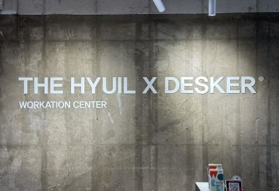 Branded signage for The Hyuil Busan, Daegyo-ro 46beon-gil, Yeongdo-gu on a grey concrete wall.